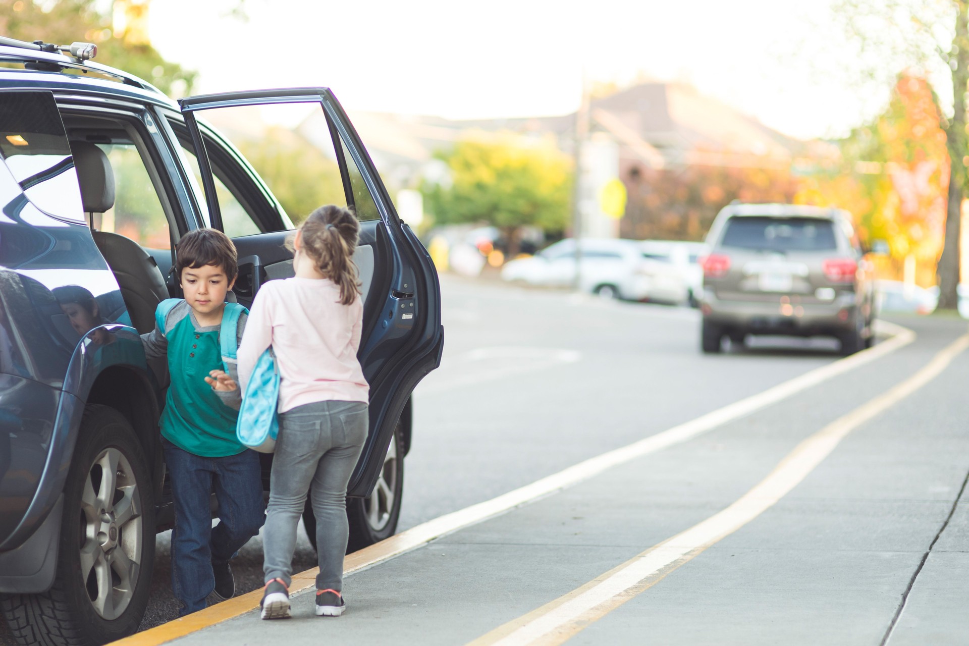 Two young students getting picked up from school